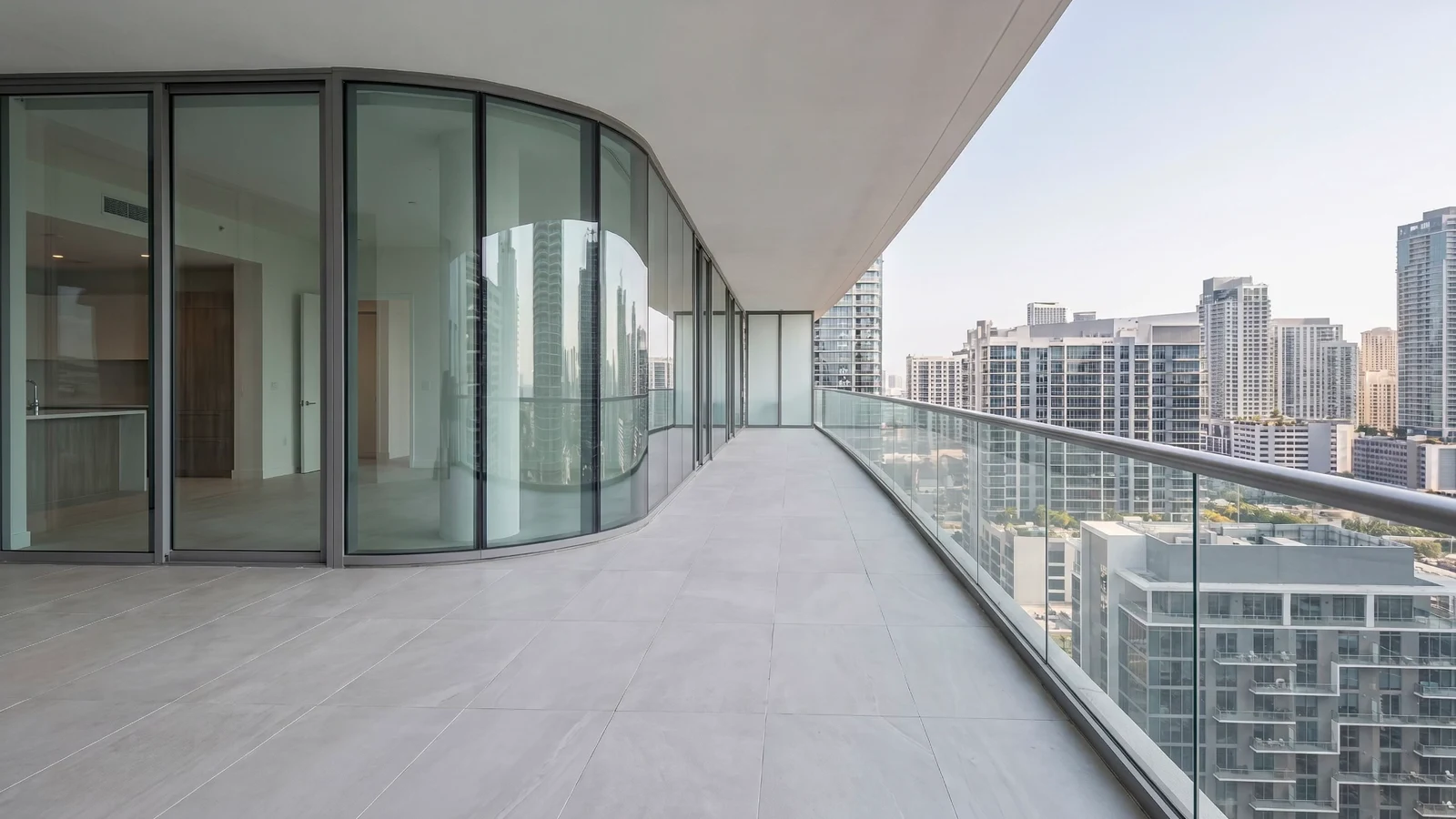 A furnished Dubai apartment balcony with outdoor seating and greenery