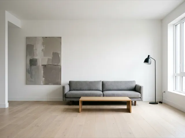 A modern minimal living room: low grey sofa, white walls, uncluttered